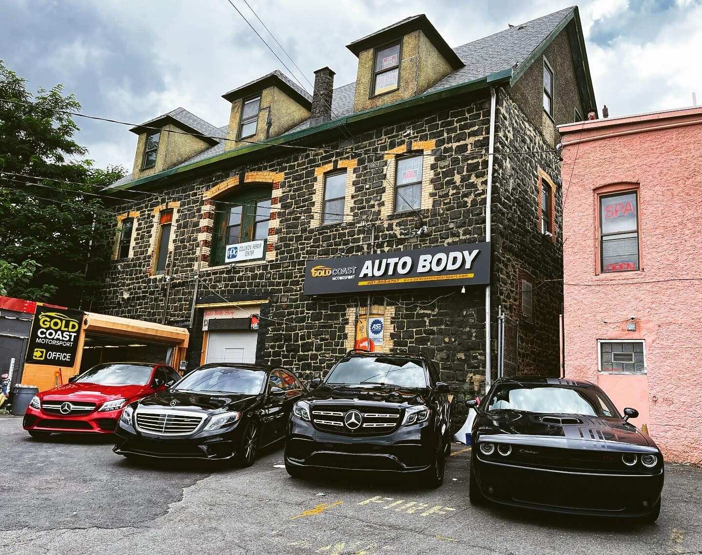 The Gold Coast Motorsport auto body shop in Edgewater with customer vehicles parked out front.